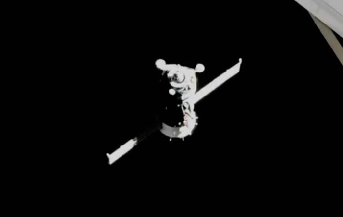 SOYUZ SPACECRAFT WITH CREW OF THREE DOCKS WITH SPACE STATION