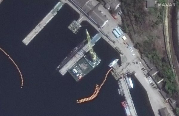 SATELLITE PHOTOS SHOW MISSILES BEING LOADED ONTO RUSSIAN SUBMARINE. DOLPHIN PENS, TOO.
